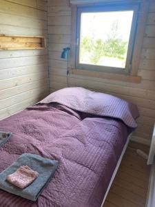 a bed in a small room with a window at Log house with a view - Bjalki in Hella