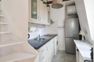 巴黎的住宿－Charming duplex studio in Paris - Welkeys，厨房配有白色橱柜和不锈钢冰箱