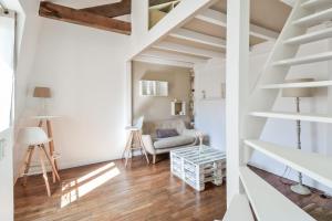 巴黎的住宿－Charming duplex studio in Paris - Welkeys，客厅拥有白色的墙壁和木地板。