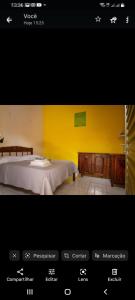 a page of a bedroom with a bed and a yellow wall at Pousada Familiar Encanto da Chapada in Carolina