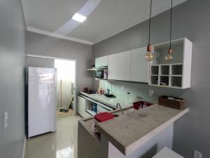 a kitchen with white cabinets and a counter top at Casas no Condomínio Dunas Residence - Santo Amaro do MA in Santo Amaro