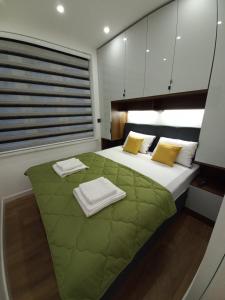 a bedroom with a large bed with a green blanket at LUX Centro Storico in Sarajevo