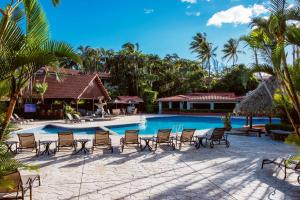 uma piscina num resort com cadeiras e palmeiras em Hilton Cariari DoubleTree San Jose - Costa Rica em San José