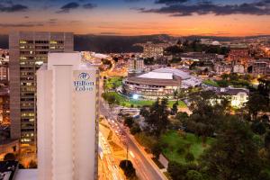 Hilton Colon Quito Hotel في كيتو: اطلالة على مدينة في الليل مع مبنى