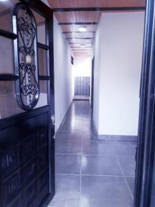 a hallway with a black door and a tile floor at HOMEFRIENDS in Cali