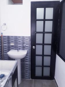 a bathroom with a black door and a sink at HOMEFRIENDS in Cali