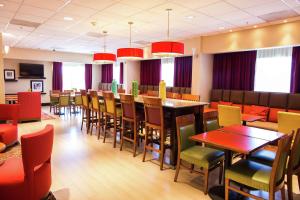 a dining room with tables and chairs in a restaurant at Hampton Inn Torreon Airport-Galerias in Torreón