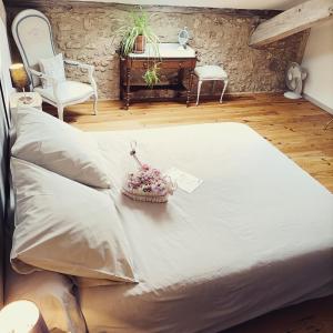 ein großes Bett in einem Zimmer mit einem Tisch und Stühlen in der Unterkunft La Grange des Anges in Blanc