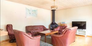uma sala de estar com cadeiras de couro e uma lareira em By The Bay room in a shared villa em Gotemburgo