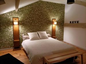 ein Schlafzimmer mit einem Bett und zwei Lampen an der Wand in der Unterkunft La Grange des Anges in Blanc