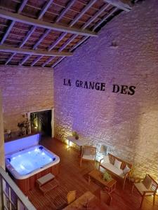 Habitación con bañera de hidromasaje en la pared en La Grange des Anges, en Blanc