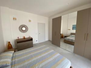 - une chambre avec un lit, une commode et un miroir dans l'établissement AleVale apartment 450mt mare, à Grottammare