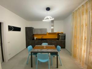 comedor con mesa y sillas azules en AleVale apartment 450mt mare, en Grottammare