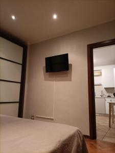 a bedroom with a flat screen tv on the wall at DOMUS VACANZE ROMANE in Rome