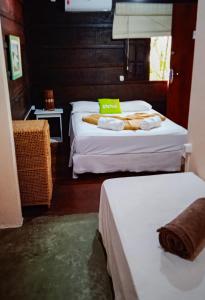 a room with two beds and a window at Pousada Canto do Forte Pertinho da Praia do Tombo in Guarujá