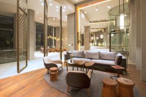 a living room with a couch and tables and chairs at DoubleTree by Hilton Santiago Kennedy, Chile in Santiago