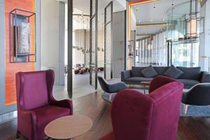 a lobby with two chairs and a couch and a table at DoubleTree by Hilton Santiago Kennedy, Chile in Santiago +58 photos