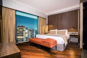 a bedroom with a bed and a large window at DoubleTree by Hilton Santiago Kennedy, Chile in Santiago