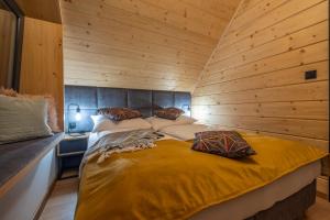 ein Schlafzimmer mit einem Bett in einer Holzwand in der Unterkunft Słone Wzgórze in Rabka-Zdrój