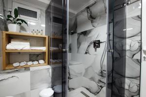 a bathroom with a shower with white and gray walls at GUEST HOUSE ÇANI in Gjirokastër