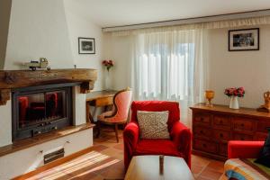 - un salon avec des chaises rouges et une cheminée dans l'établissement Casamia Juliette, à Valsolda