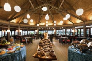 a dining room with tables filled with food at Hilton Moorea Lagoon Resort & Spa in Papetoai