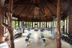 un gimnasio con cintas de correr y equipos de ejercicio en un edificio en Hilton Moorea Lagoon Resort & Spa en Papetoai