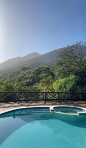 a swimming pool with a view of the mountains at Mooi Guest House in Ilhabela