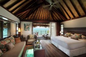 帕佩托艾Hilton Moorea Lagoon Resort & Spa的一间带床的卧室和一间客厅