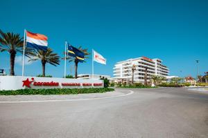 une route devant un bâtiment arborant des drapeaux dans l'établissement Mangrove Beach Corendon Curacao All-Inclusive Resort, Curio, à Willemstad