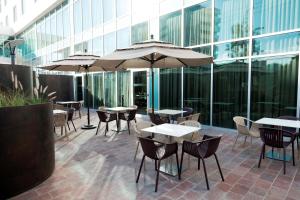 a patio with tables and chairs and an umbrella at Hampton Inn by Hilton Leon in León