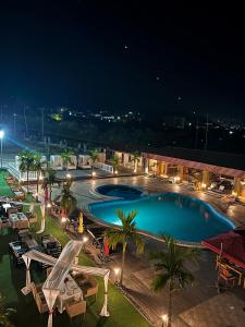 a large swimming pool at night with tables and chairs at Marcsons Hotels and Resorts in Limbe
