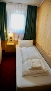 a bed in a room with a window at Hotel Hafner in Stuttgart