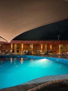 a large swimming pool in a hotel at night at Marcsons Hotels and Resorts in Limbe