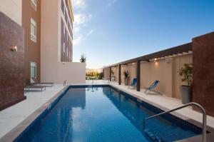 - une piscine au milieu d'un bâtiment dans l'établissement Homewood Suites by Hilton Queretaro, à Querétaro