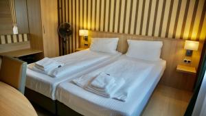 a bedroom with a bed with white sheets and pillows at Hotel Hafner in Stuttgart