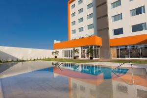 ein Hotel mit einem Pool vor einem Gebäude in der Unterkunft Hampton Inn & Suites by Hilton Paraiso in Paraíso