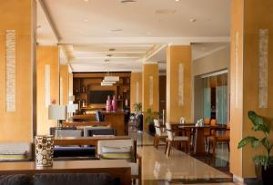 a lobby with tables and chairs in a building at Hampton Inn & Suites by Hilton Paraiso in Paraíso