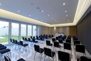 Hampton Inn & Suites by Hilton Paraiso في بارايسو: قاعة اجتماعات مع كراسي وطاولة وشاشة
