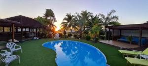 a swimming pool in a yard with chairs and a house at Villa Totiri in Tevaitoa