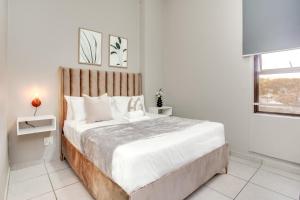 a bedroom with a large bed with a wooden headboard at The Bolton in Rosebank in Johannesburg