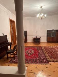 a large room with a rug and a piano at Maximus Wine Cellar,Bagdati Wine House in Bagdatʼi