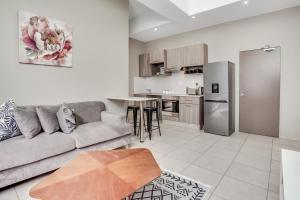 a living room with a couch and a kitchen at The Bolton serviced apartments Rosebank in Johannesburg