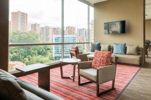 a living room with a view of a large window at Hampton by Hilton Medellin in Medellín