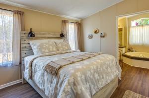 Schlafzimmer mit einem Bett, einer Badewanne und einem Waschbecken in der Unterkunft Secluded Rural Home in Normangee! 