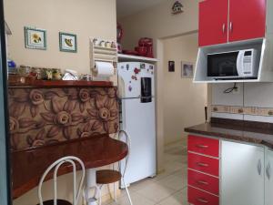 a kitchen with a white refrigerator and red cabinets at Casa em Pomerode_SC in Pomerode
