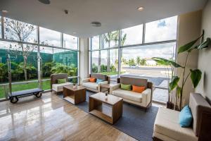 a living room with furniture and a large window at Hampton By Hilton Santo Domingo Airport in Boca Chica