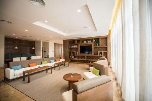 um lobby com sofás e mesas e uma televisão em Hampton By Hilton Santo Domingo Airport em Boca Chica