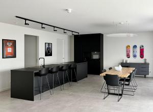 a kitchen with a table and some black chairs at Design Apartment with 60m² terrace - heated inside pool and wellness facilities - very close to the beach in Cadzand