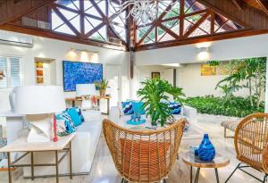 ein Wohnzimmer mit Stühlen, Tischen und einer Decke in der Unterkunft Sunny Vacation Villa No 96 in San Rafael del Yuma